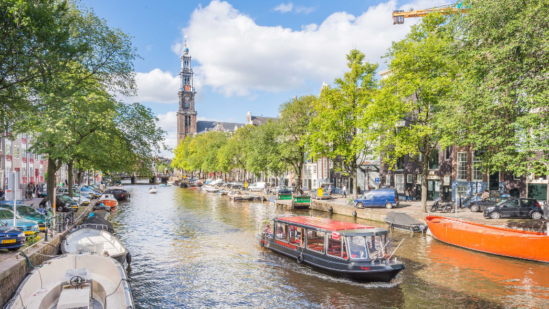 Amsterdam - en kanalb�t glider runt i kanalen.